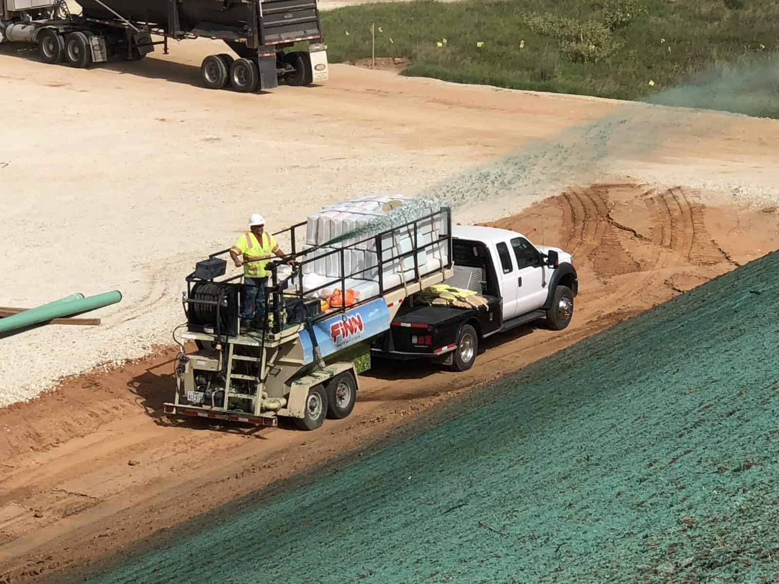 image of a man hydroseeding a field