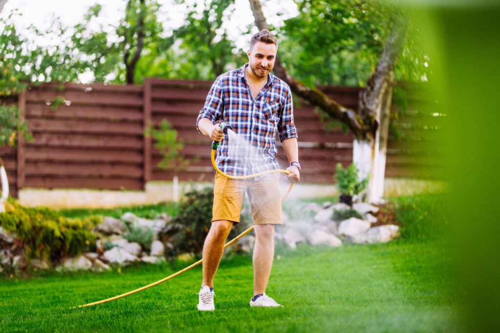 Man watering his lawn with a hose